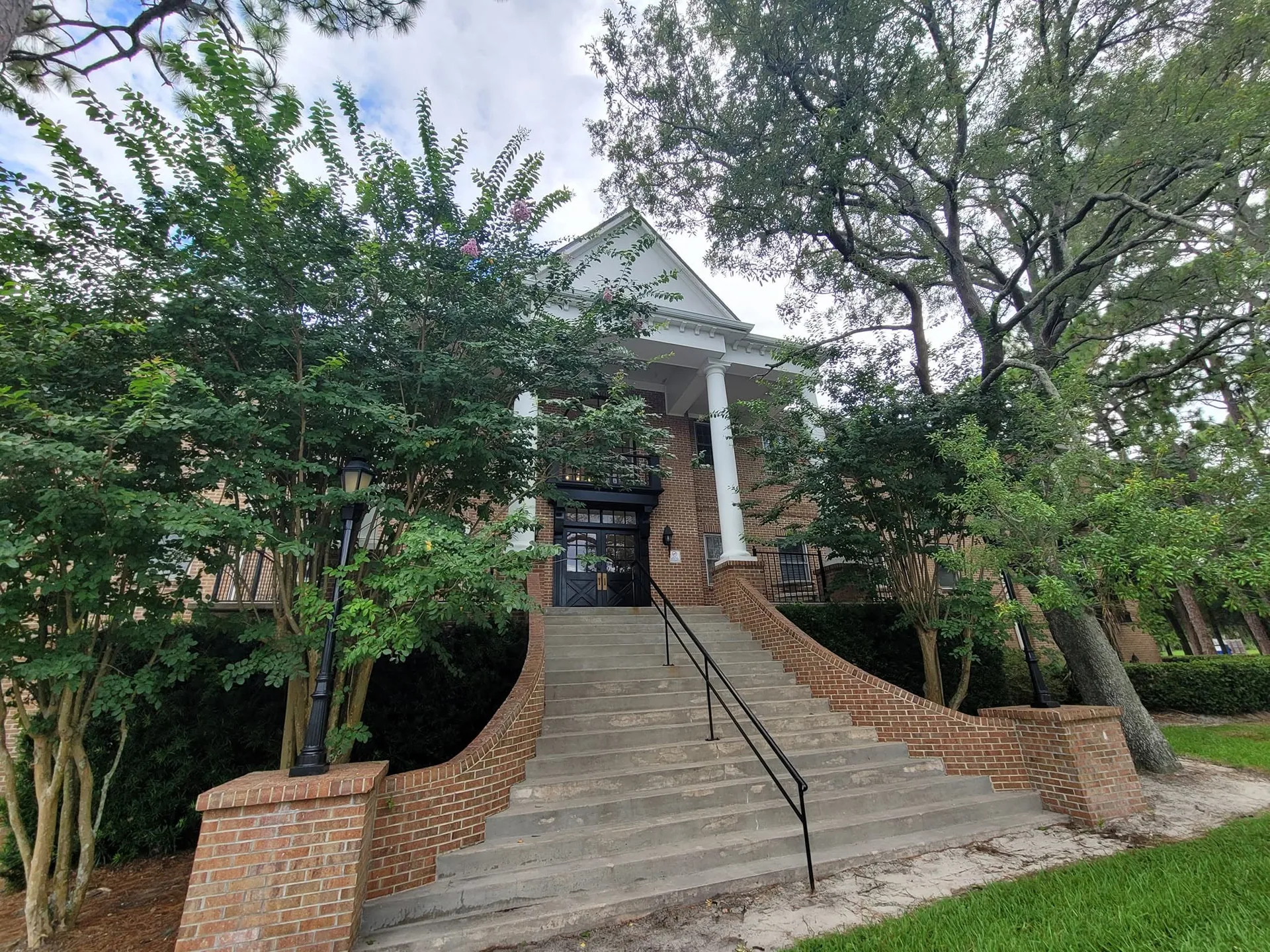 Brick building wide concrete stairs white columns portico crape myrtles, Sanford